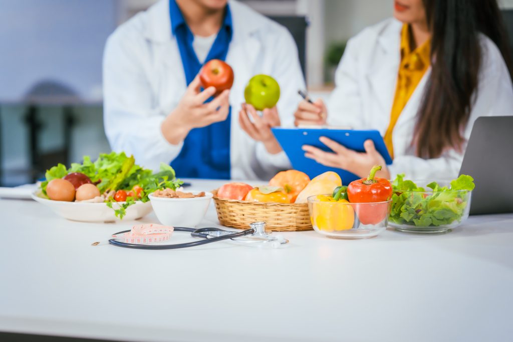 especialista en nutricion clinica muestra manzanas a paciente